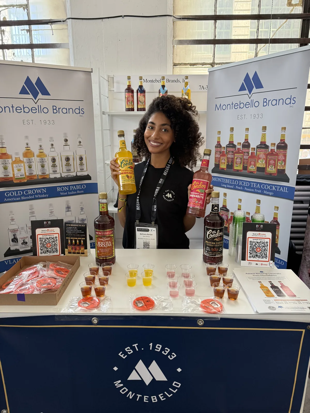 A Montebello team member holding El Condor margaritas at the booth
